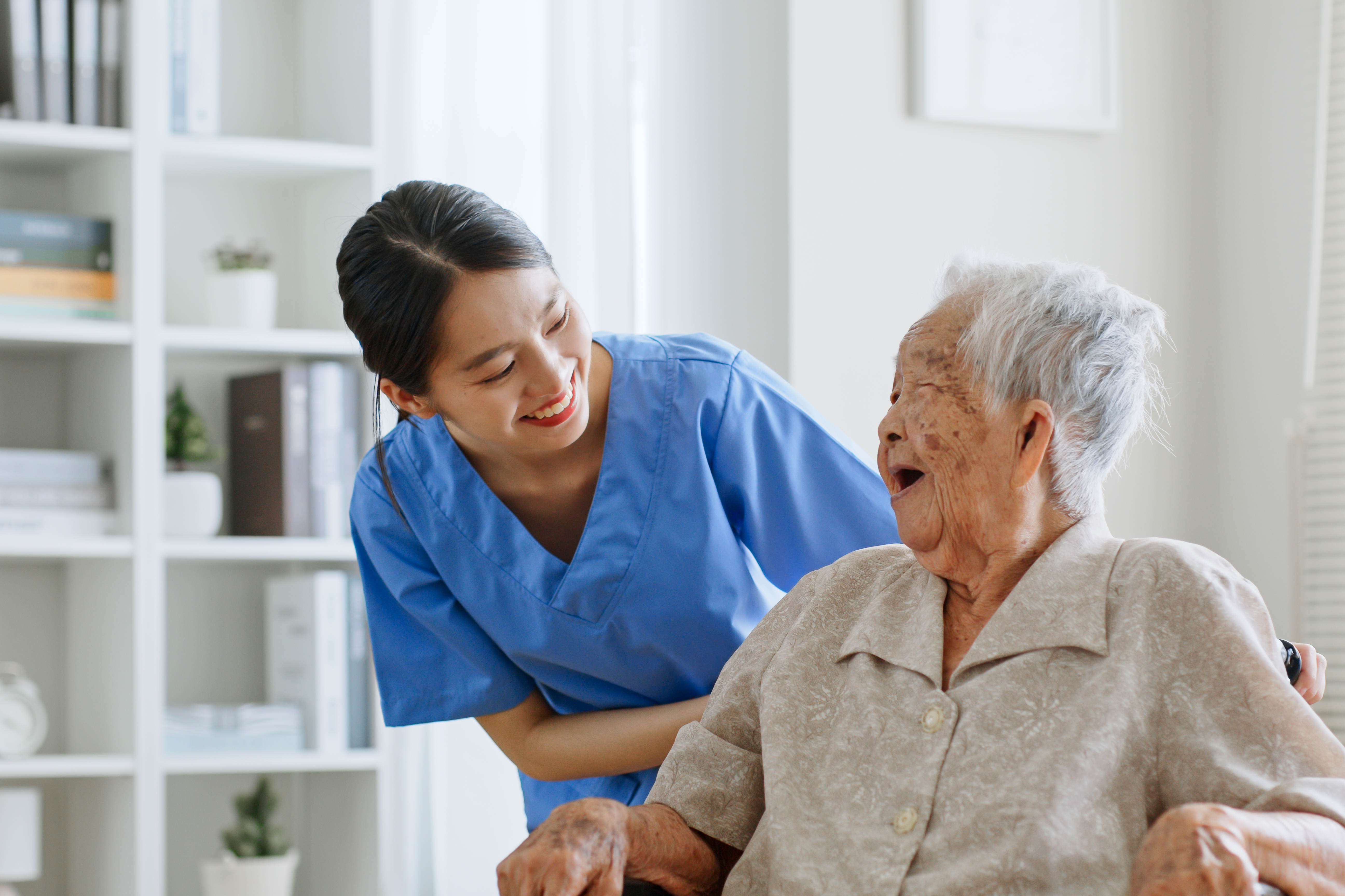 Asian caregiver talking warmly with elderly resident at VHome Care Centre care centre George Town